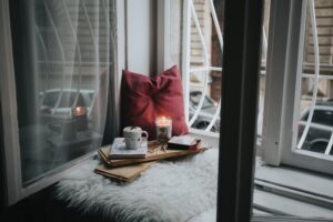 There is a picture of a pillow, candles, and a try put on a window and it highlights the theme of beauty in the poem, The bird of dedication. 