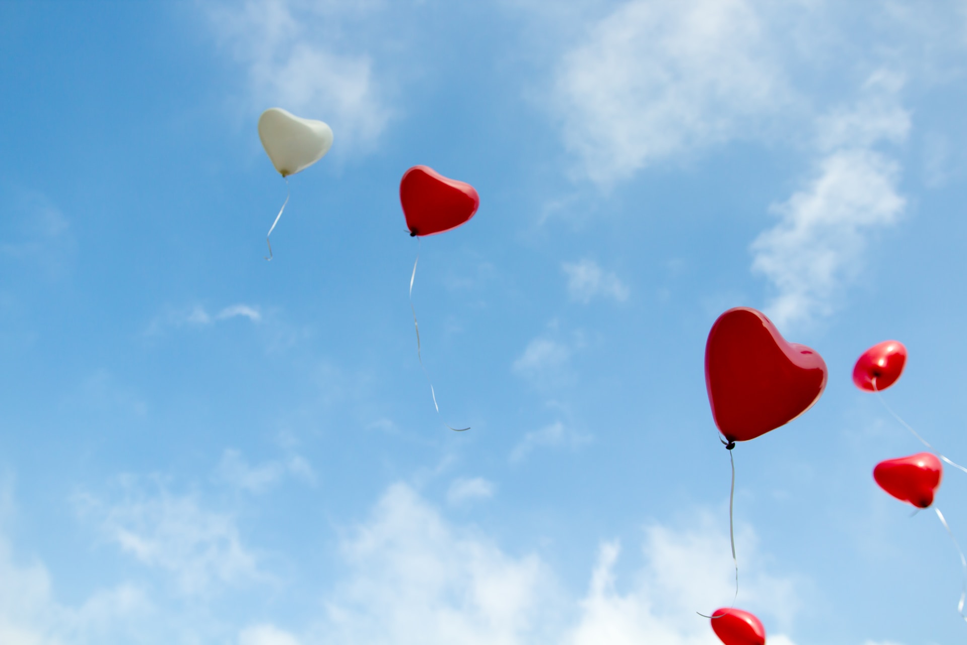 The is an image of a sky filled with red and white heart balloons. These balloons are indicating the beginning of romance in literature. 