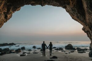 A couple holding hands under a cave on a bench that symbolizes that it is Time To Say Goodbye!