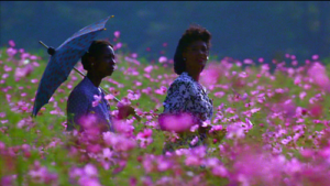 This is a scene from one of the movies based on books, The Color Purple where two women are walking in a field.