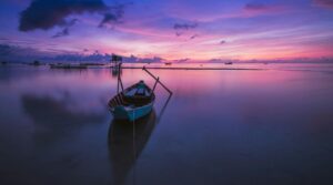 Green Boat With Oars on Both Side during Golden Hour Panoramic Photo shows the theme of peace in The Quiet Moments.